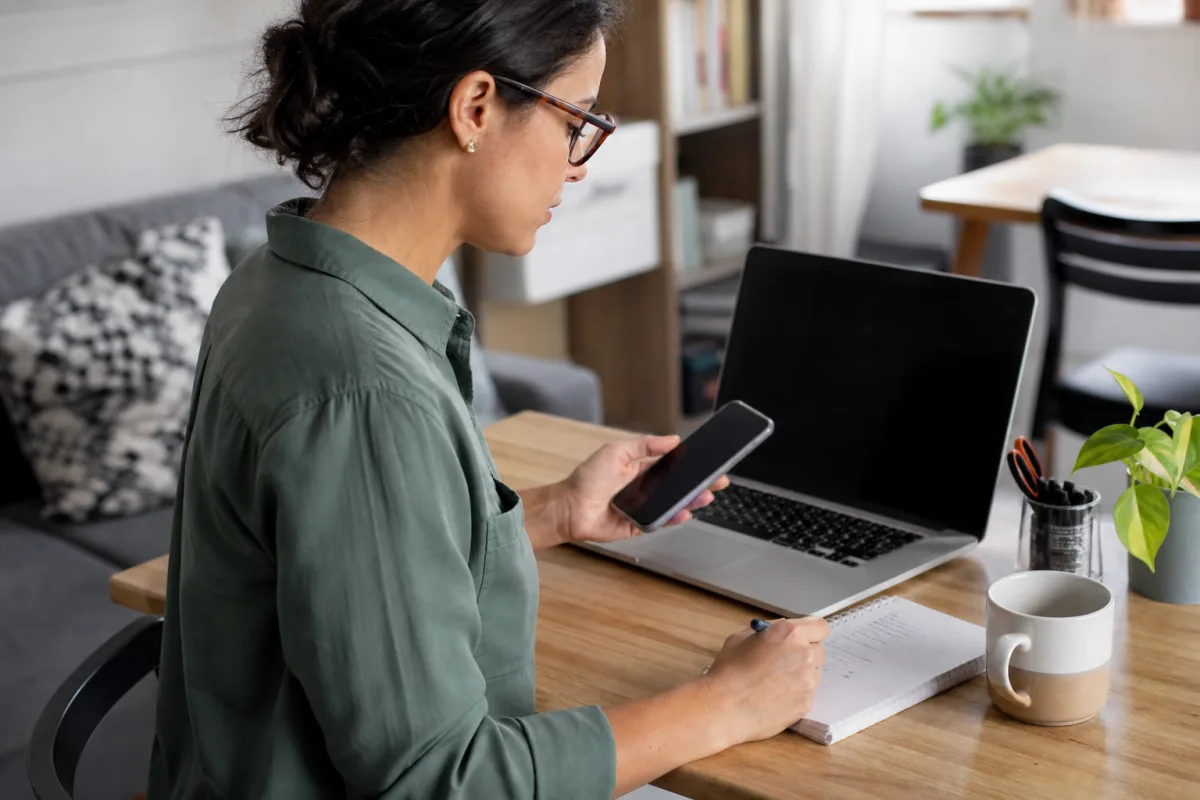 A cautious job seeker checking an employer on a laptop and phone